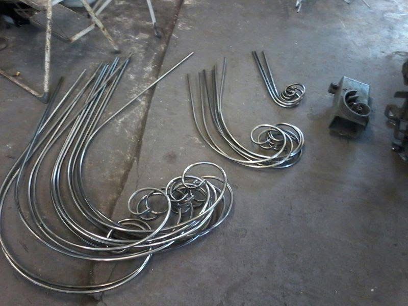 Handgebogen stalen sierkrullen voor handgesmede kroonluchter, klaar voor opbouw in smederij Papendrecht